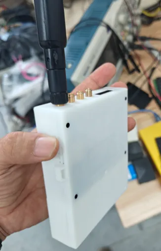 The G33 in-vehicle keyless entry device, a white unit with an external antenna, held in a hand